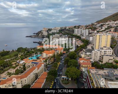 Les vues aériennes de Funchal, Madère révèlent une ville animée nichée entre des collines luxuriantes et l'Atlantique bleu profond, mêlant nature et charme. Banque D'Images