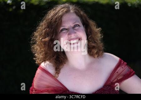 Femme en robe de soirée rouge souriante Banque D'Images