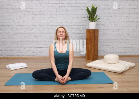 Femme faisant du yoga dans le studio de yoga - papillon Banque D'Images