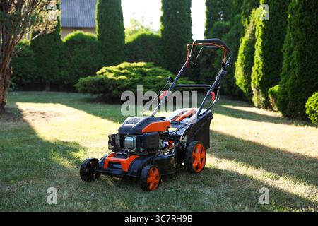Une tondeuse à gazon sur l'herbe verte dans le jardin Banque D'Images