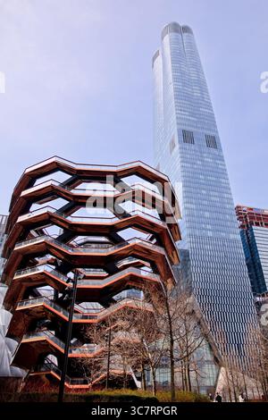 Les escaliers emboîtables recouverts de cuivre du navire s’élèvent contre les tours de verre de Hudson Yards sur le West Side de Manhattan sous un ciel lumineux pastel du matin. Banque D'Images