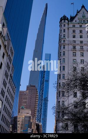 Le profil élancé de la Steinway Tower s'élève derrière la façade ornée dorée du Plaza Hotel sur la rangée des milliardaires de Manhattan sous un ciel bleu vif. Banque D'Images
