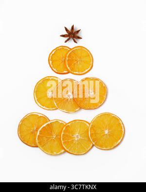 Silhouette d'un arbre de Noël en orange séchée et anis étoilé sur fond blanc. Idée pour la nouvelle année. Banque D'Images