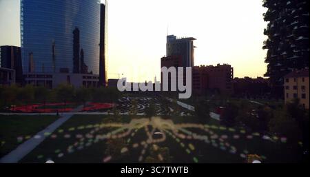 Paysage urbain montrant des chemins sinueux en béton au parc au crépuscule, avec des sentiers bokeh colorés Banque D'Images