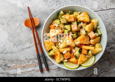 Salade asiatique de légumes de fruits Rojak avec fromage tofu assaisonné de sauce sucrée et épicée gros plan dans un bol sur la table. Vue horizontale de dessus Banque D'Images