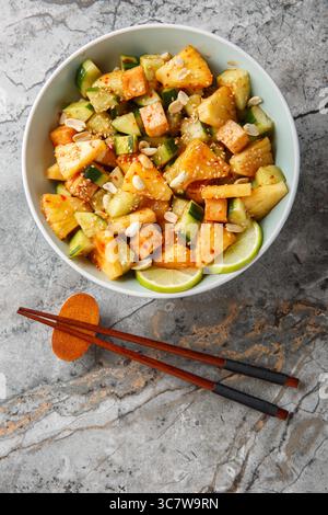 Salade de légumes aux fruits Rojak avec fromage tofu gros plan dans un bol sur la table. Vue de dessus verticale Banque D'Images