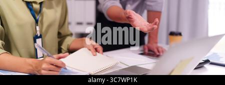 Scène de réunion collaborative dans un espace de travail d'entreprise. Les employés analysent les données et communiquent des idées pour atteindre les objectifs du projet. Banque D'Images