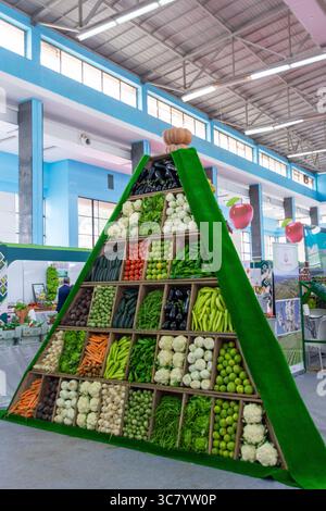 Légumes frais exposés sur une forme pyramidale dans un marché de la ville d'Alger, Algérie. Banque D'Images