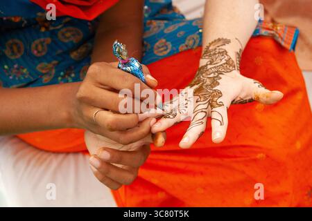 Gros plan des mains d'une femme décorées avec du henné dans le cadre d'un rituel pré-mariage, Inde Banque D'Images