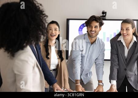 Sympathique divers jeunes gens d'affaires ayant du plaisir à collaborer sur un projet d'entreprise Banque D'Images