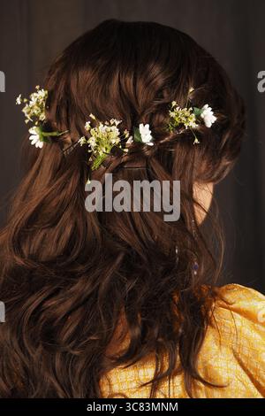Cheveux ornés de fleurs dans une coiffure créative Banque D'Images