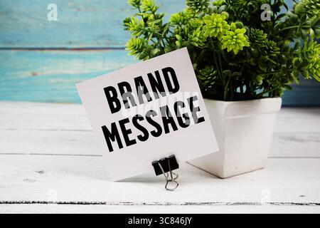 Texte du message de marque écrit sur carte de papier sur fond en bois Banque D'Images