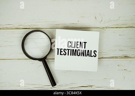 Témoignage client message texte sur note collante avec loupe sur fond en bois Banque D'Images