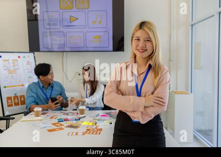ux, ui, concepteur d'applications mobiles regarde la caméra, concepteur web regarde la caméra, environnement de travail dans le bureau du web et application mobile Banque D'Images