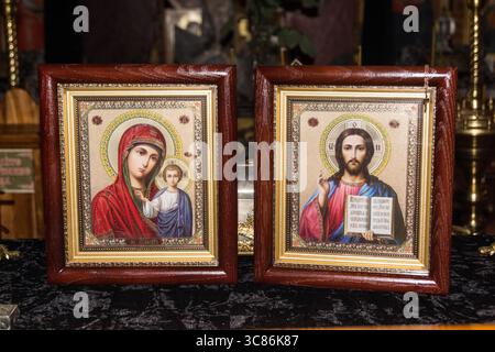 Des icônes magnifiquement travaillées de la Vierge Marie avec enfant et Jésus ornent un autel en bois, améliorant l'atmosphère spirituelle dans un espace calme pendant le Banque D'Images