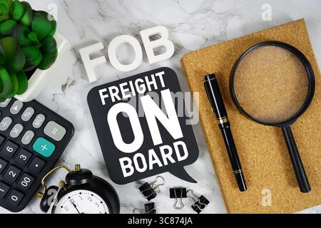 FOB Freight sur le texte de bord avec calculatrice, réveil et loupe sur fond de marbre Banque D'Images