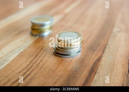 Les pièces s'empilent sur la table en bois près du partmone. Monnaie européenne un et deux euros pour le concept d'affaires de commerce. Banque D'Images