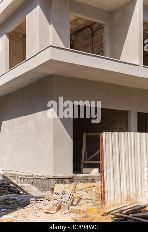 Les activités de construction sont évidentes sur un chantier en développement avec une structure en béton, des charpentes exposées et des matériaux de construction dispersés Banque D'Images