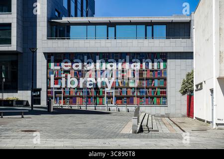 Bibliothèque publique de Tallaght à Dublin, Irlande, façade moderne avec affichage bilingue « Leabharlann / Library » et exposition de verre sur le thème du livre. Banque D'Images