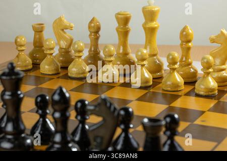 Vue rapprochée d'un échiquier avec des pièces en noir et blanc disposées pour un jeu. Banque D'Images