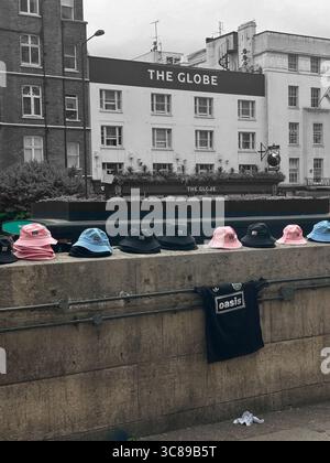 Chapeaux et tee-shirt Oasis 'seau' à vendre à Baker Street, Londres W1 pour les concerts Oasis à Wembley août 2025 Banque D'Images