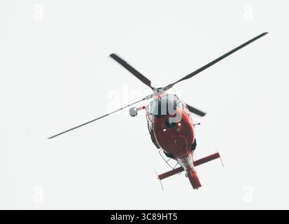 Un dauphin Eurocopter de la Garde côtière plane au-dessus de l'action lors de la régate annuelle de la Coupe Stotesbury. Banque D'Images
