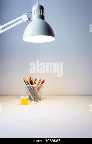 carnet de croquis illuminé par lampe et jeu de crayons de couleur sur table, dessin et passe-temps, concept de retour à l'école Banque D'Images