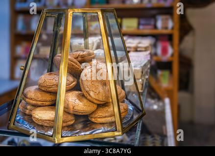Une pile de biscuits aux amandes traditionnels est exposée dans un écrin en laiton vintage et en verre dans une charmante vieille confiserie à Istanbul, en Turquie Banque D'Images