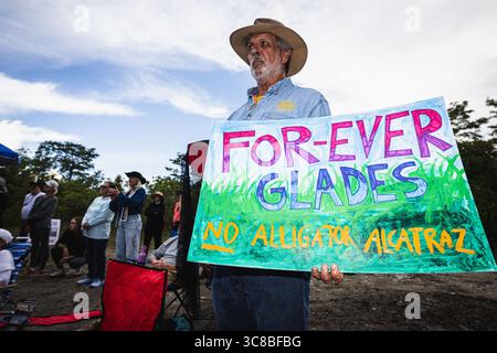 Ochopee, Floride, États-Unis. 3 août 2025. L'activiste tient une pancarte de protestation alors que les dirigeants de groupes religieux de tout l'État de Floride se sont rassemblés pour une veillée sur le site du centre de détention nommé ''˜Alligator Alcatraz' par l'État de Floride pour tenir un espace et prier pour les détenus qui ont été touchés par les grèves de la faim et une variété d'autres questions environnementales et de droits humains. (Crédit image : © Dave Decker/ZUMA Press Wire) USAGE ÉDITORIAL SEULEMENT ! Non destiné à UN USAGE commercial ! Banque D'Images
