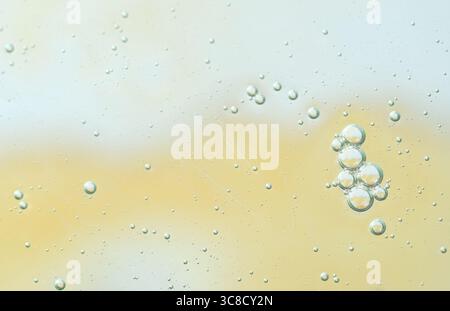 Bulles d'air claires dans un liquide doux avec des tons de dégradé jaune et bleu. Fond abstrait propre et minimal. Bulles d'air transparentes dans le liquide léger Banque D'Images
