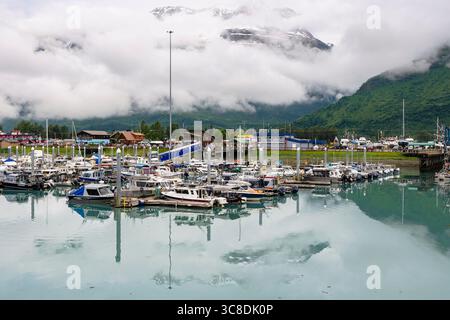 Bateaux amarrés dans le port et vue sur les montagnes par un matin brumeux sur la côte sud. Valdez, Alaska, États-Unis Banque D'Images