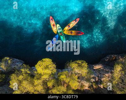 Vue aérienne de drone de kayaks colorés avec des gens sur la mer bleue Banque D'Images