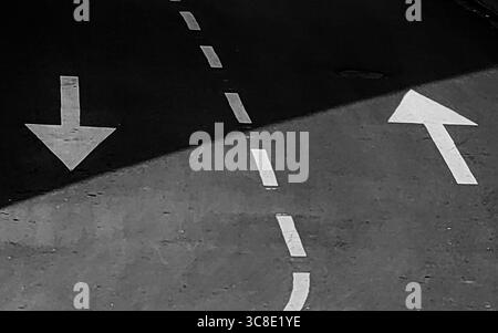 Urban Yin-Yang : Arrows and Shadow Play on the Street. Teintes monochromes. Banque D'Images