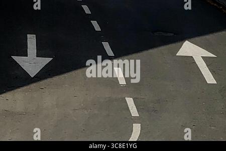 Urban Yin-Yang : Arrows and Shadow Play on the Street Banque D'Images