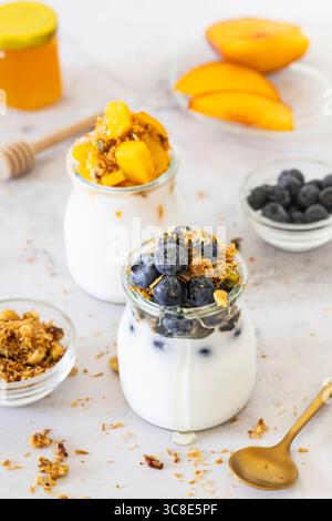 Deux bols nourrissants pour le petit-déjeuner avec yaourt à la noix de coco sans produits laitiers servi avec muesli sans gluten fait maison. Banque D'Images