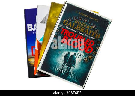 Sélection de livres reliés avec livre de sang troublé par Robert Galbraith (pseudonyme de JK Rowling) sur le dessus isolé sur fond blanc Banque D'Images