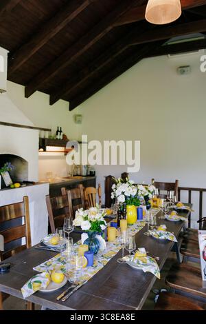 Table à manger élégante dans le restaurant décorée de citrons jaunes, de fleurs et de vaisselle élégante. Pièce maîtresse florale fraîche, design rustique et moderne. F Banque D'Images