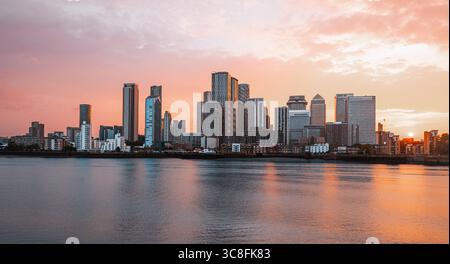 Coucher de soleil sur les gratte-ciel de Canary Wharf, Londres, avec des nuages spectaculaires et une lumière dorée. Banque D'Images