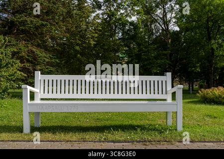 Emblématique banc en bois blanc dans Haapsalu Park, Estonie, un jour ensoleillé d'été Banque D'Images
