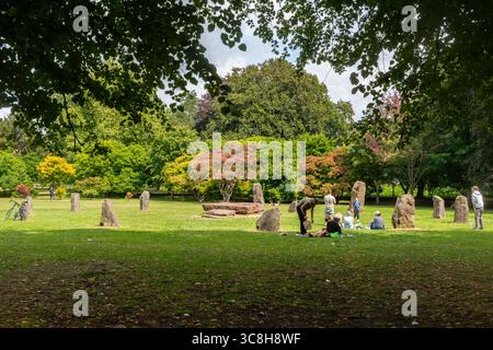 Les gens profitent d'une journée d'été ensoleillée autour de Gorsedd Stone Circle à Bute Park, un parc public dans la ville de Cardiff, pays de Galles du Sud, Royaume-Uni Banque D'Images