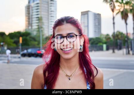 Jeune femme souriant à l'extérieur dans un cadre urbain de ville. Banque D'Images