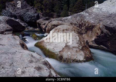 Eau brumeuse coulant à travers Rocky Stream à Neuquen, Argentine - exposition longue durée de la journée Banque D'Images