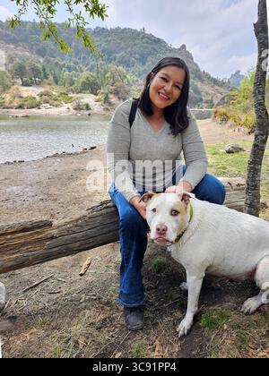 Une femme adulte latina passe du temps à l'extérieur avec son chien de soutien émotionnel comme thérapie pour le stress et l'anxiété Banque D'Images