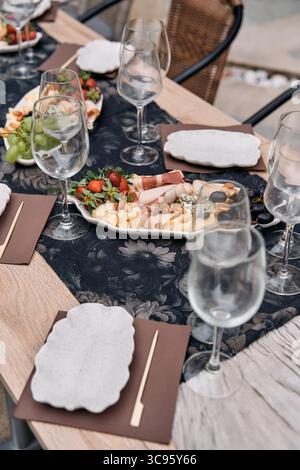 Expérience gastronomique élégante avec un plateau de charcuterie décoré avec goût, assortiment de viandes, légumes et fruits frais accompagnés de Crystal GL Banque D'Images