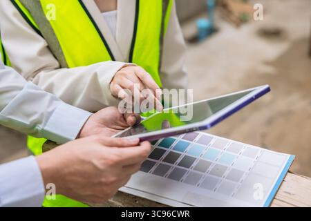 gros plan ingénieur de construction avec design d'intérieur regardant l'écran de la tablette pour le logiciel de nuancier Banque D'Images