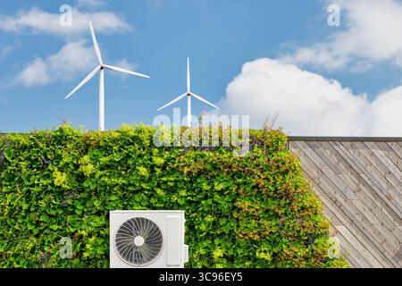 Pompe à chaleur à source d'air sur un bâtiment durable vert avec des centrales verticales et des éoliennes Banque D'Images