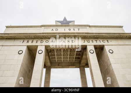 Accra, Ghana - 27 mai 2017 : vue de l'emblématique Arche de l'indépendance, sa pierre blanche et dure contrastant avec le ciel couvert, gravée avec « liberté et justice ». Banque D'Images