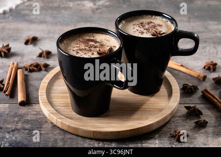 Chai Latte en Mug noir avec épices (anis étoilé et cannelle) Banque D'Images