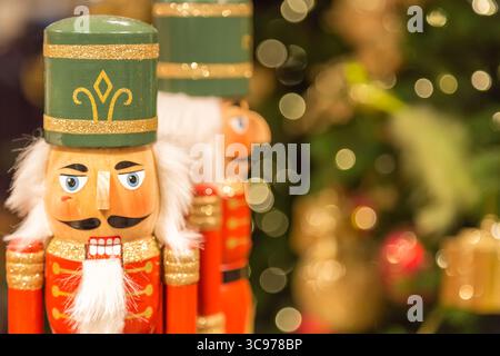 Soldat Casse-noisette statues debout devant l'arbre de Noël décoré avec des lumières bokeh. Banque D'Images