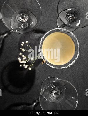 Verre à cocktail sidecar avec bordure en sucre et verres à martini vides sur fond sombre Banque D'Images